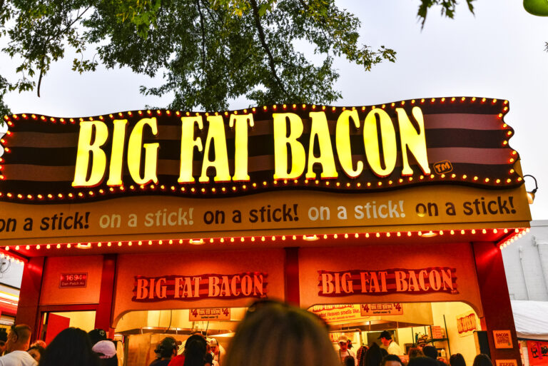 Falcon Heights, Minnesota, USA - Big Fat Bacon Food Stand with people waiting in line, at the Minnesota State Fair in Falcon Heights, Minnesota. The MN State Fair is a 12 day annual event.